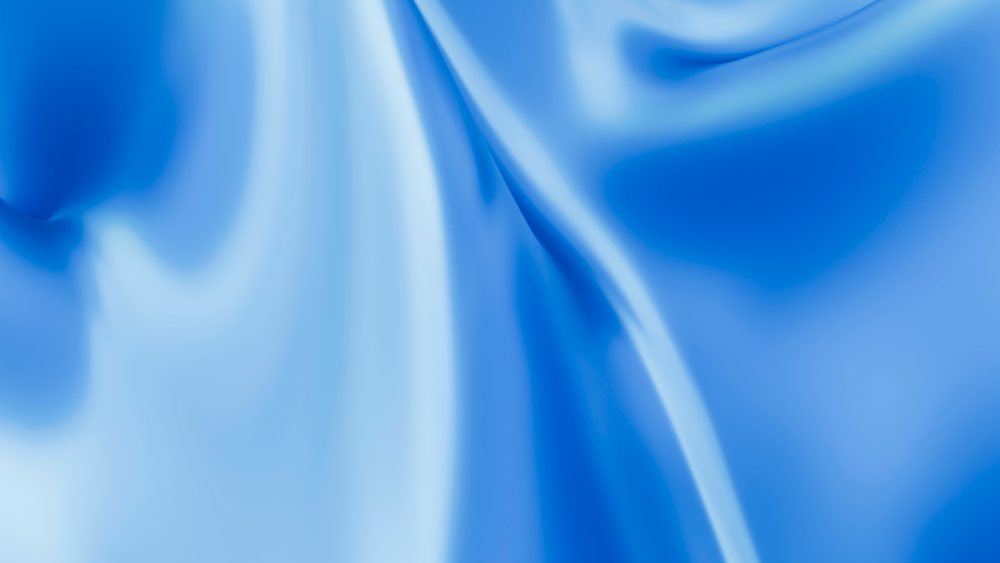 Silky blue fabric with smooth folds and shiny texture draped in a studio setting.