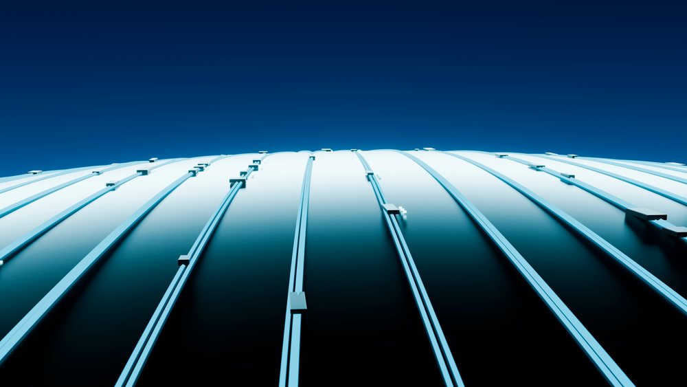 Curved metal roof with vertical steel beams under a clear blue sky in a modern architectural outdoor setting.
