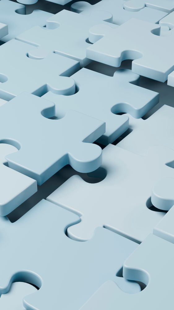Close-up view of scattered blue interlocking 3D puzzle pieces forming an abstract pattern.