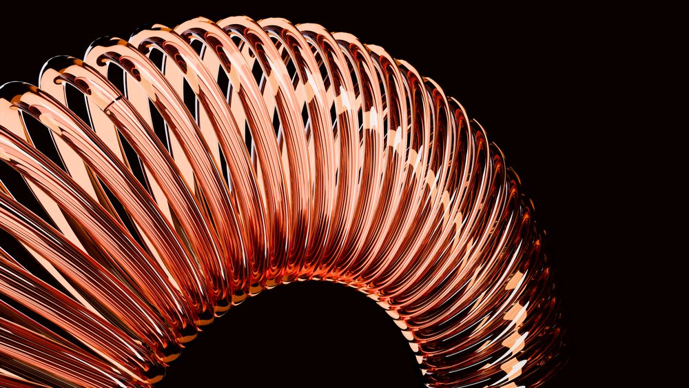 Close-up of a curved, shiny copper-colored metal spring coil isolated on a black background.