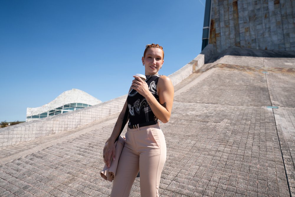 Businesswoman holding a coffee cup outdoors by a modern architectural building in an urban environment on a sunny day, businesswomen, Spain.