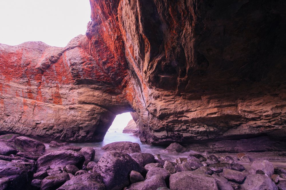 Natural Devils Punch bowl rock formation and ocean cave with rocky shore on Oregon coast, USA.