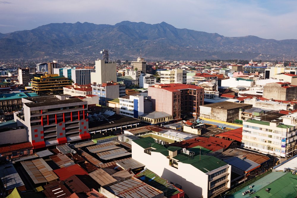 San Jose cityscape featuring urban buildings and mountains under clear daylight, Costa Rica.