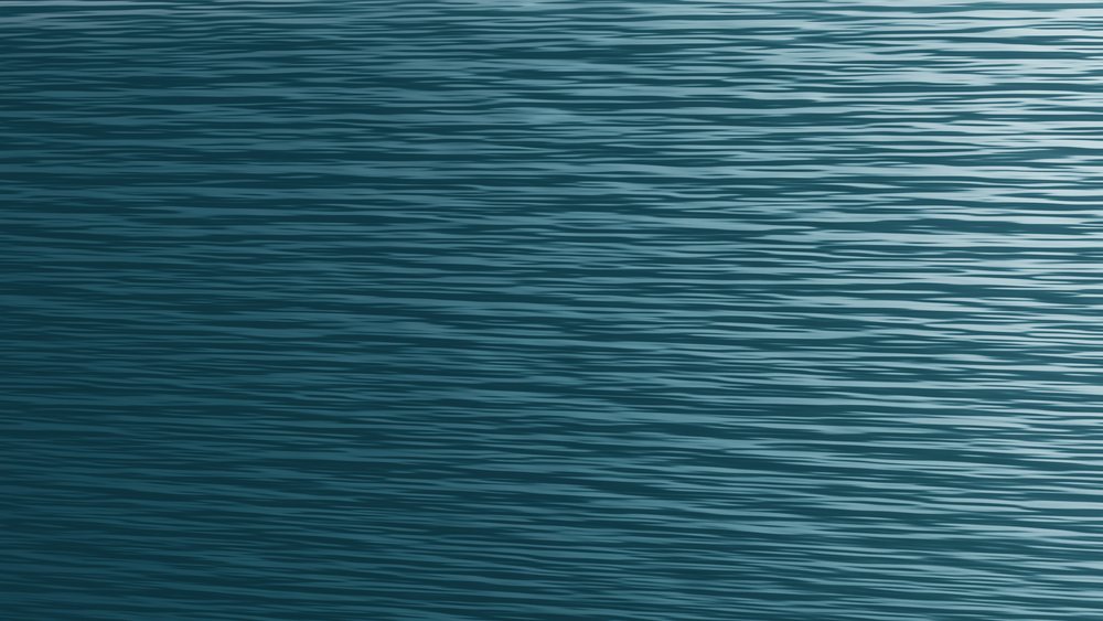 Ocean water surface with gentle waves and ripples creating a pattern under natural light.