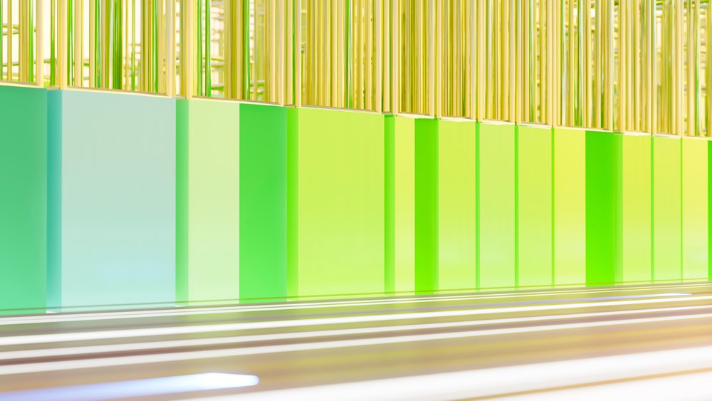 Modern architectural wall featuring vertical green and yellow glass panels with light reflections.