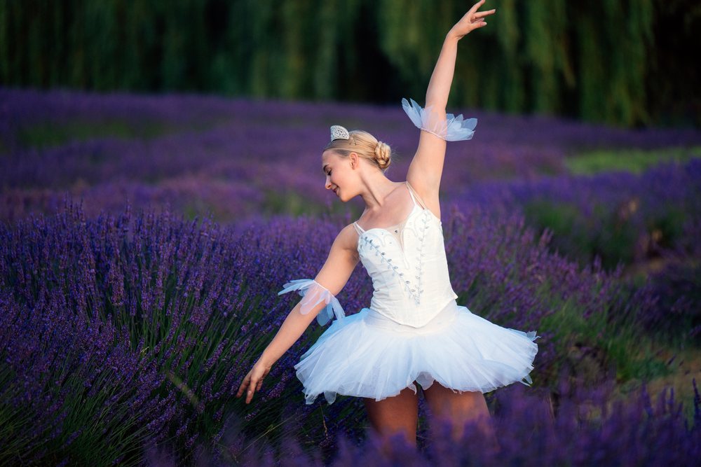 A ballerina in a white tutu gracefully dances in a lavender field, WA, USA.