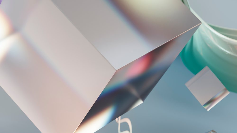 Multiple metallic reflective cubes float against a blue background with colorful light reflections and abstract smooth shapes nearby.