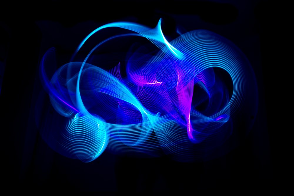 Abstract LED light painting featuring blue and purple curved glowing lines on a dark background.
