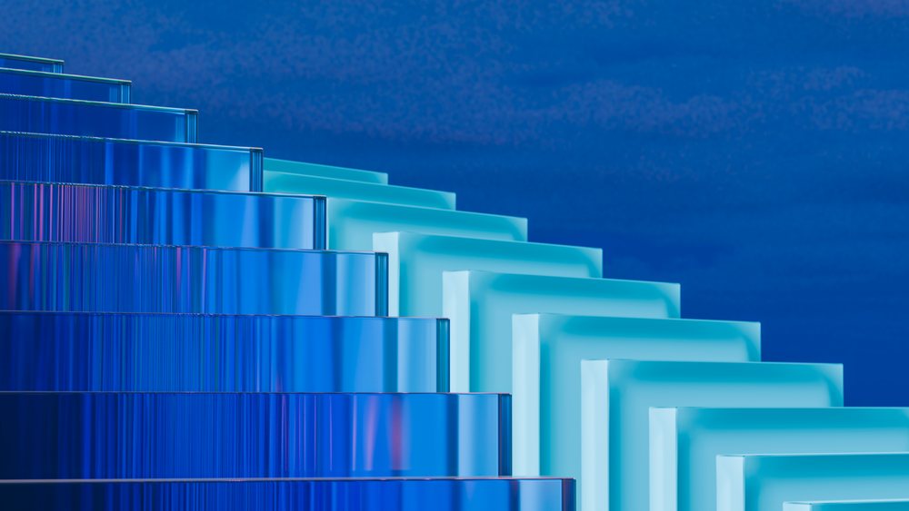 Blue glass rectangles stacked symmetrically against a blue background forming a modern abstract geometric design.