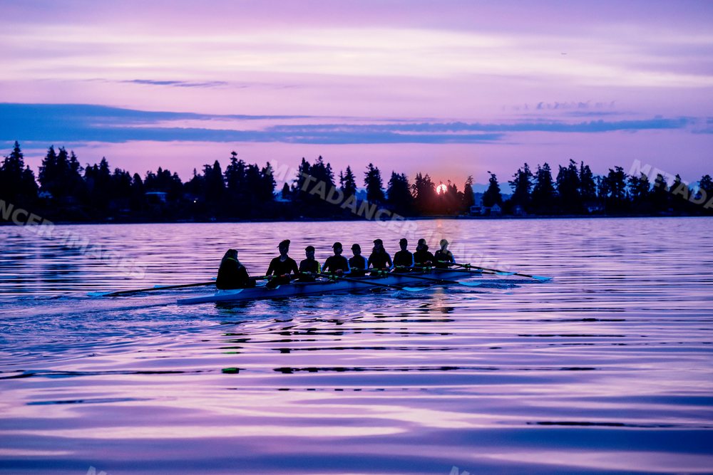 A rowing team practicing on calm water at sunset in wa USA