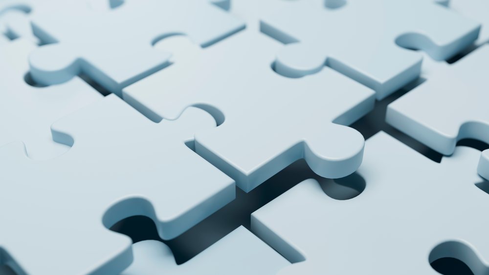 Close-up image of blue interlocking jigsaw puzzle pieces showing connection and shape details on a smooth flat surface.