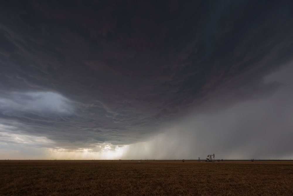 Supercell thunderstorm forms over an open field with oil pumpjacks, in the Great Plains, Storm Chasing, Morton, Texas, USA.