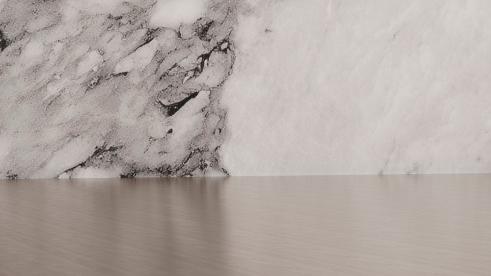 Interior room featuring a marble-textured wall and light wood floor creating a smooth, elegant environment.