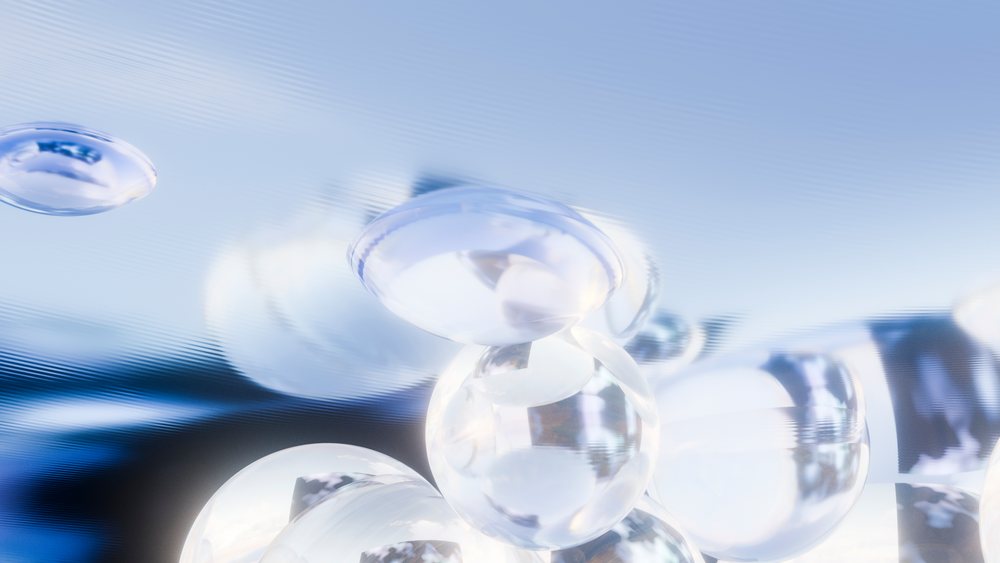 Close-up of transparent water droplets on a smooth reflective surface demonstrating surface tension and fluid dynamics.