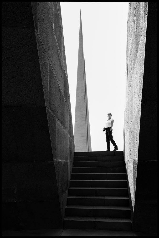 Person standing on stone stairs a camera at the outdoor Armenian Genocide Memorial, Yerevan, Armenia.
