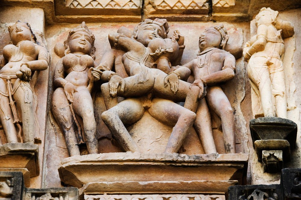 Stone carved erotic sculptures on an ancient temple wall at Khajuraho, Madhya Pradesh, India.