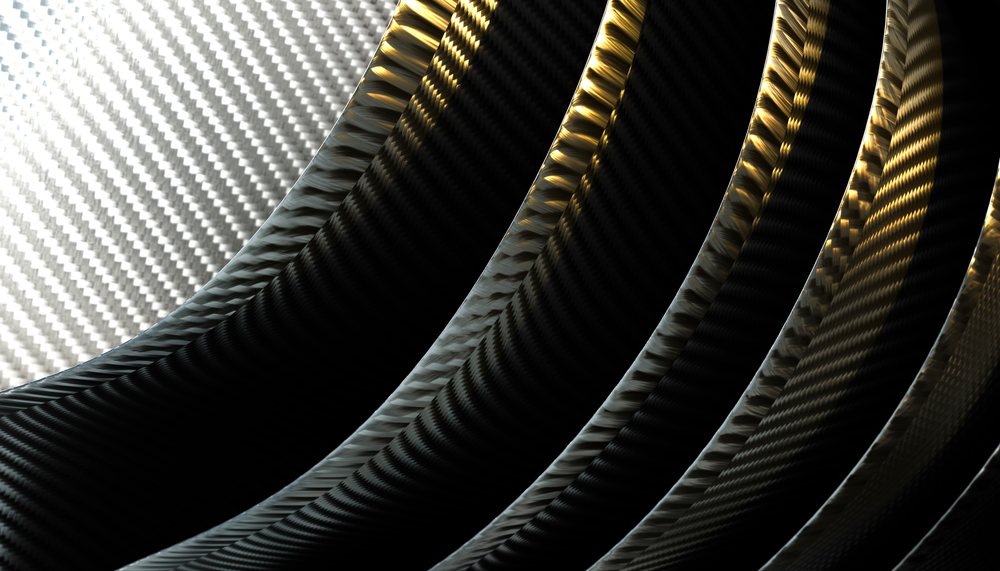 Curved rings made of woven carbon fiber with black and gold light reflections, showing detailed texture.