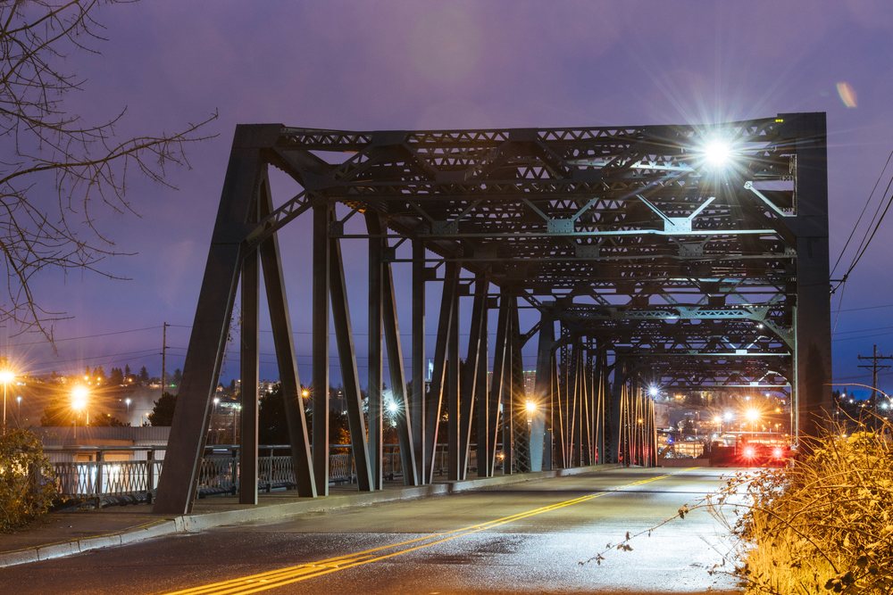 Steel bridge with roadway and illuminated street lights in Tacoma at night, WA, USA.
