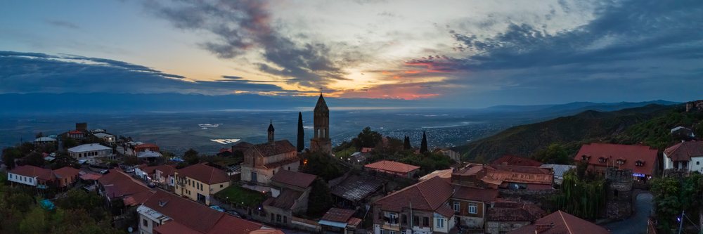 St George's Church with bell tower and cross, at Dawn overlooking a hillside village and mountains, Skylines, Sighnaghi, Georgia.