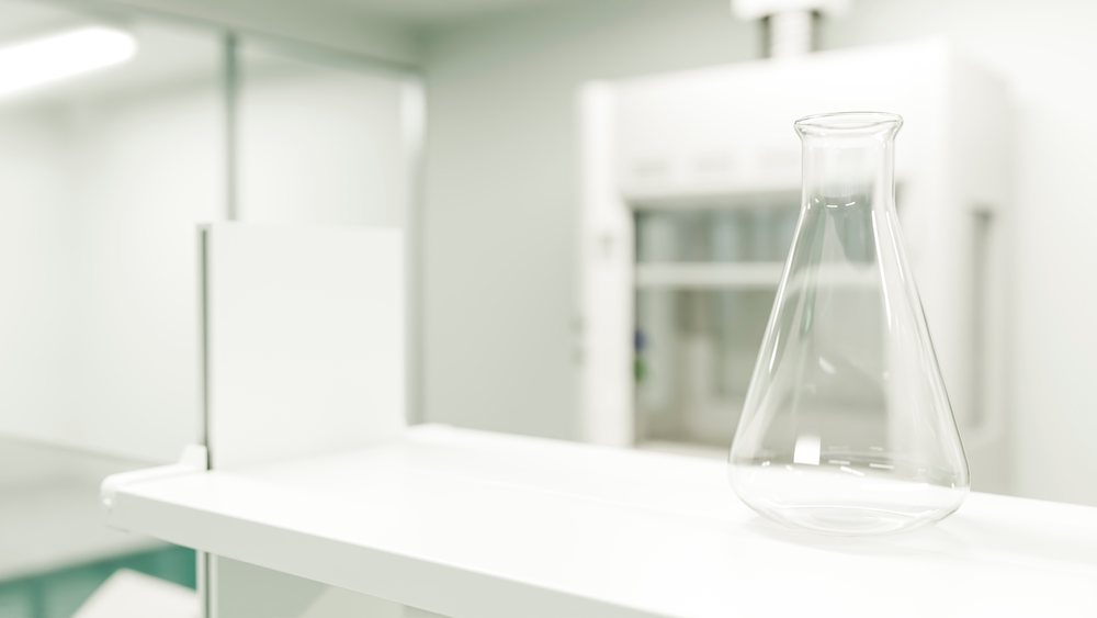 Empty glass flask on a white shelf in a clean, modern chemistry laboratory environment.