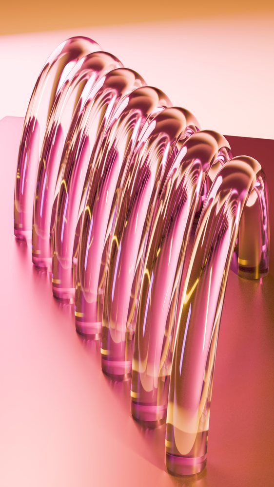 Curved transparent glass tubes arranged symmetrically on a reflective pink surface in an abstract artistic design.