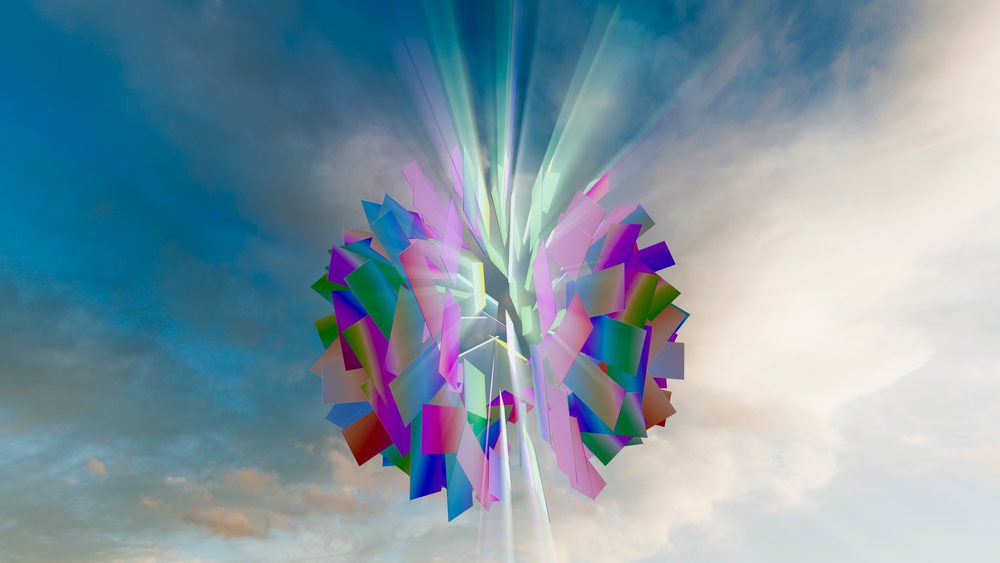 Colorful abstract digital sculpture composed of multicolored geometric shapes is illuminated against a dramatic sky background.