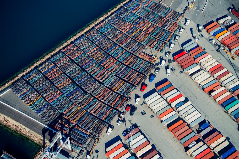 Aerial view of shipping containers and container trucks in the port at Long Beach, California, USA.