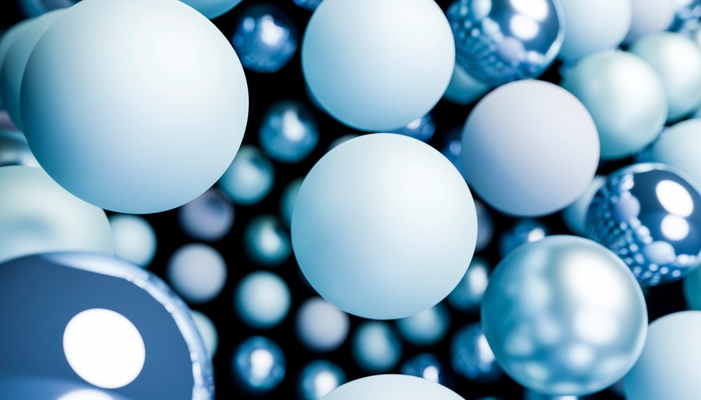 Close-up view of multiple floating blue shiny spheres with reflections