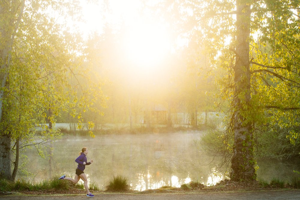 Runner jogging along a misty trail, Bainbridge Island, Wa, USA.