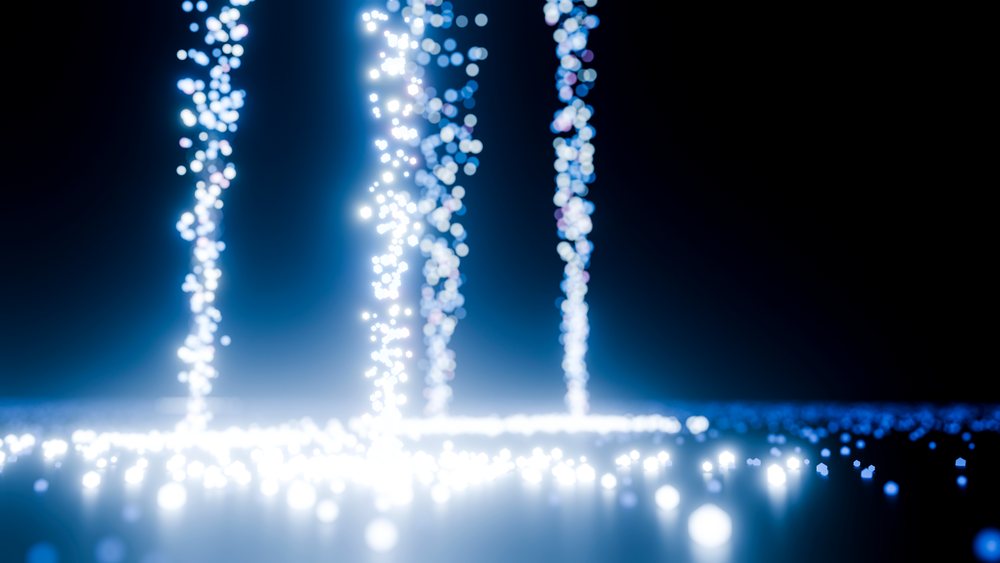 Multiple vertical streams of glowing blue and white light particles float over a dark background in abstract digital art.