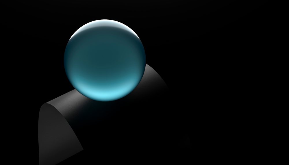 A glowing blue glass sphere resting on a matte black curved base against a dark background in a minimalist setting.