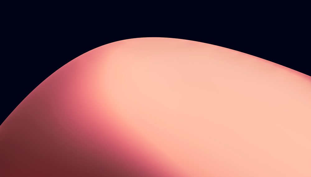 An abstract smooth orange curve with soft gradient lighting on a dark background.