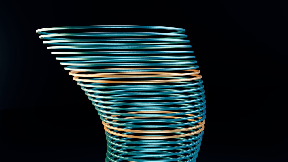 Stack of smooth, shiny blue and orange metallic rings forming a spiraled geometric cylindrical shape against a black background.