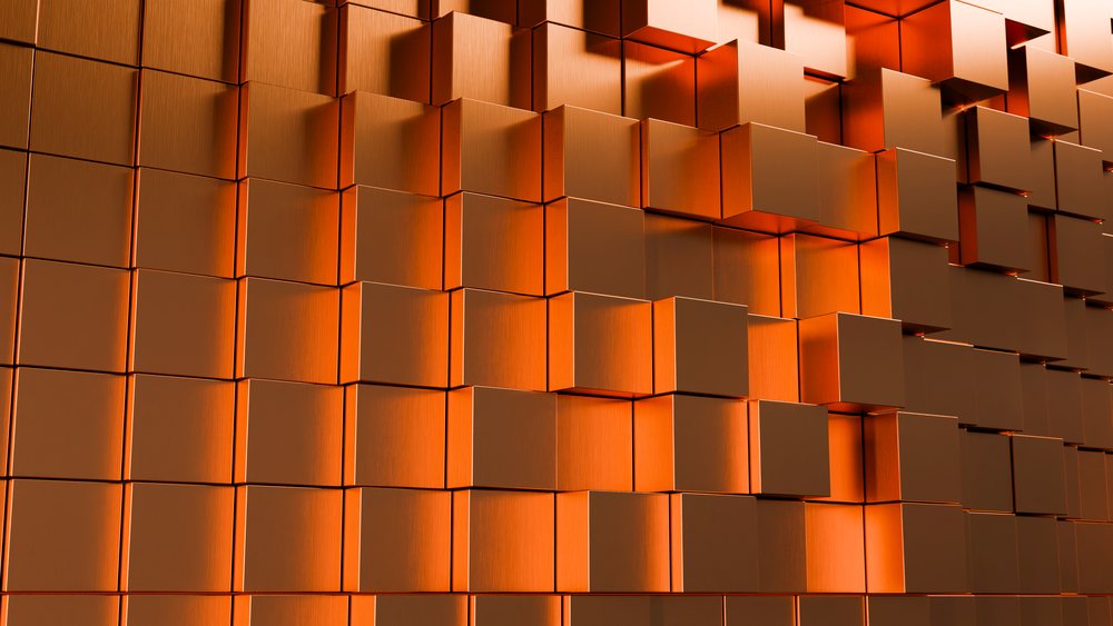 Orange 3D cubes arranged in a raised geometric grid pattern form an abstract textured wall.