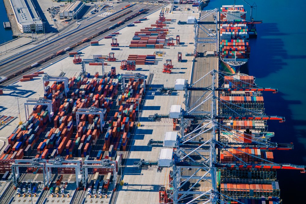 Container port with cargo cranes and stacked shipping containers alongside rgo ships at a major port in Long Beach, Port of Long Beach, CA, USA.