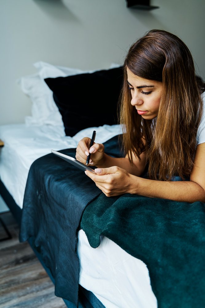 A woman uses a digital pen on a tablet