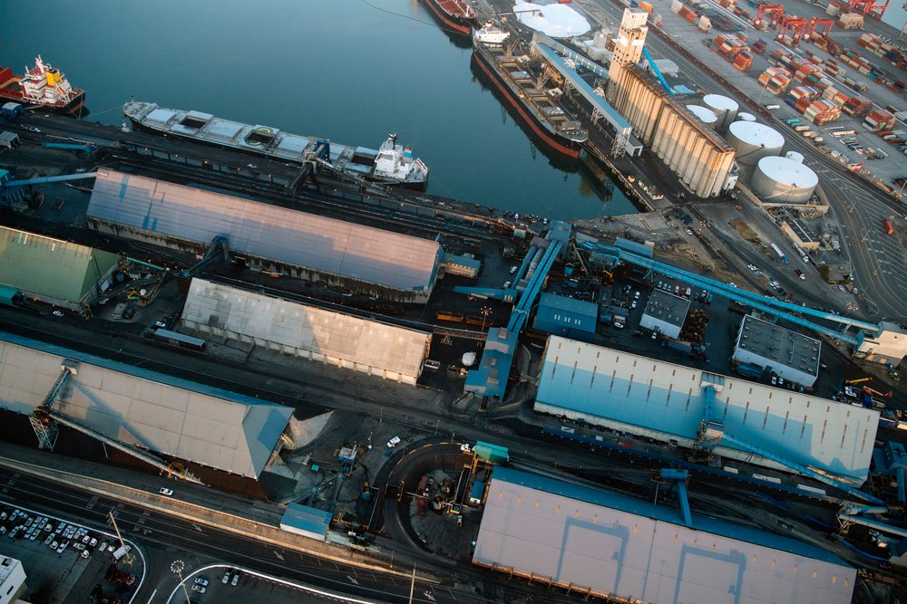 Aerial view of a major container port showing container ships docked, warehouses, loading and unloading operations, and numerous shipping containers, a major container port, CA, USA.