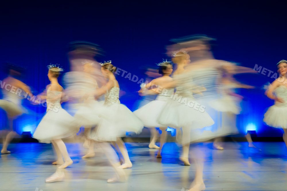 Young ballerinas perform a spinning ballet dance on stage