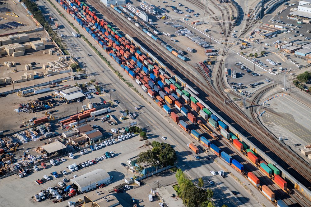Freight train carrying multicolored shipping containers at a major port in lifornia, a major port in California, CA, USA.
