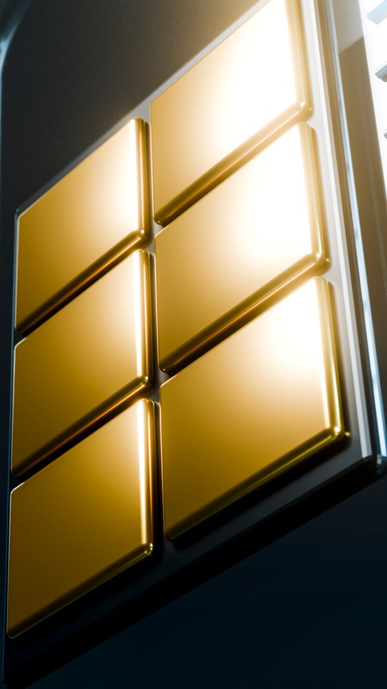 Closeup of six stacked gold bars with shiny reflective surfaces symbolizing wealth and investment value.