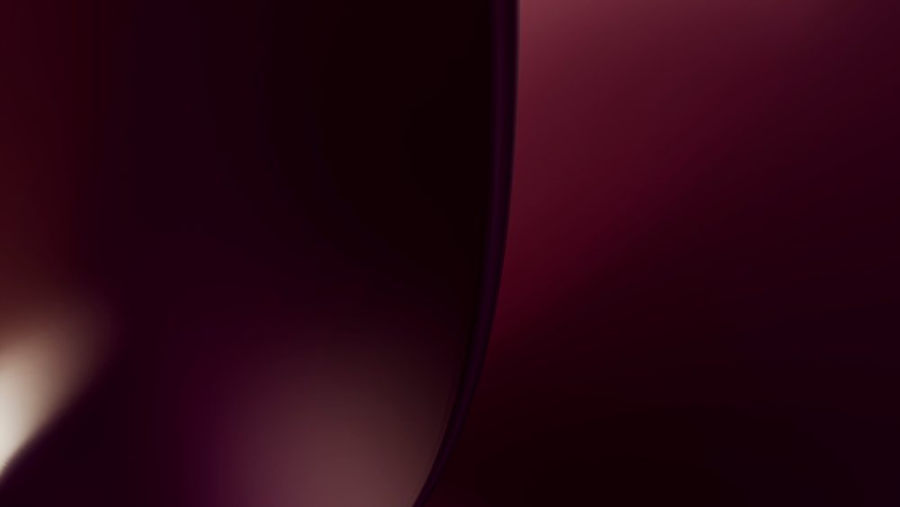Digital art featuring a dark abstract background with smooth purple gradient and curved shapes creating a fluid modern design.