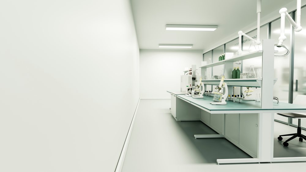 Clean and organized laboratory workspace with microscopes, test tubes, flasks, and scientific glassware on a white bench inside a modern lab.