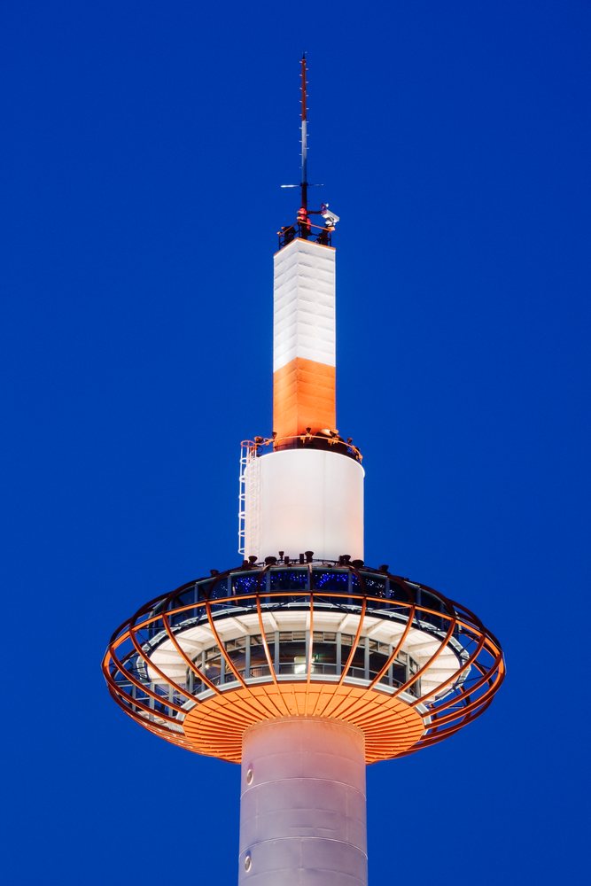 Kyoto Tower illuminated at night with a clear deep blue sky, Honshu, Japan.