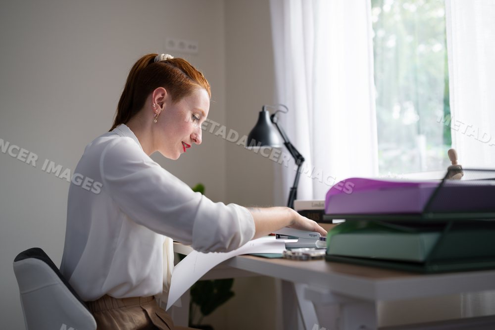 A white woman staples documents