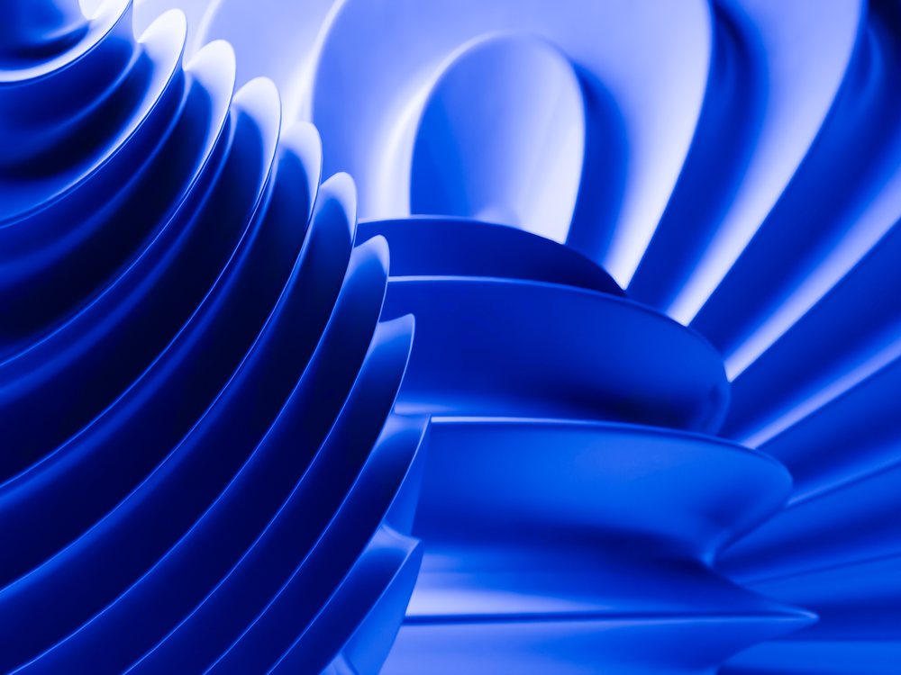 A close-up of blue abstract curved shapes with layered smooth surfaces creating a modern artistic composition.