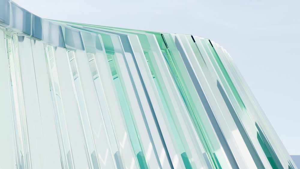 Modern architectural design featuring layered glass panels with reflective surfaces against a clear blue sky.