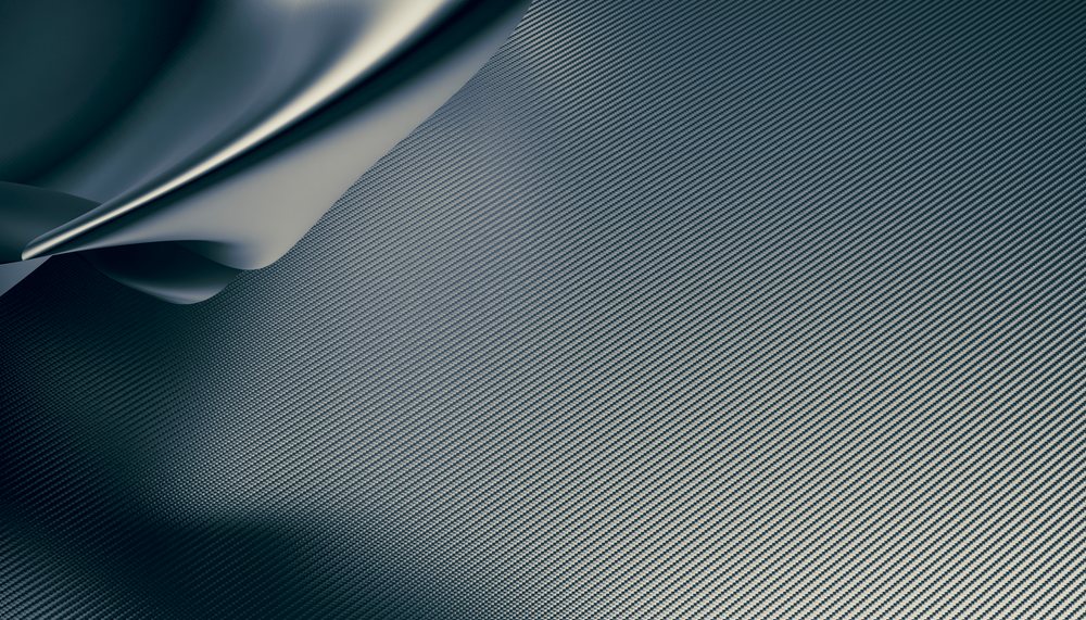 Close-up view of a folded carbon fiber fabric showing the woven texture and pattern.