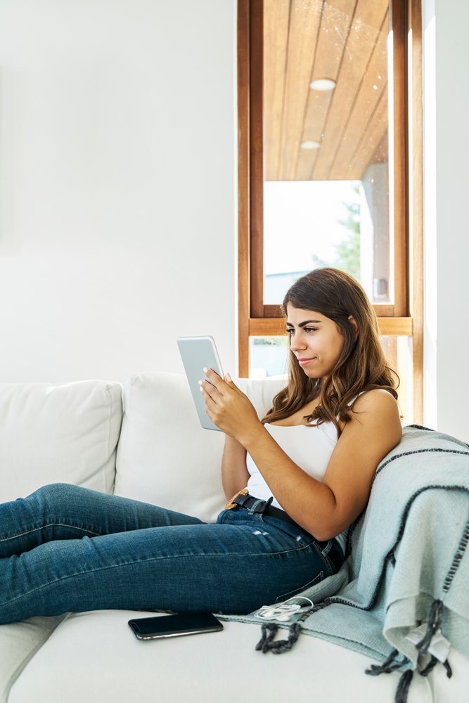 A young white woman is using a tablet