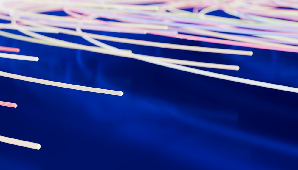 Fiber optic cables illuminated with soft light above a blue background in a technology setting.