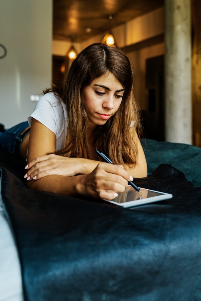Woman writing on a digital tablet